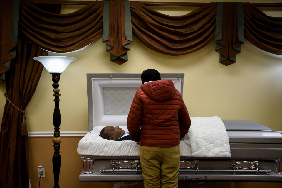 Samantha Emanuel reacts while viewing the body of her father, Samuel Emanuel Jr., 55, who died from complications from the coronavirus disease (COVID-19), during a private viewing held for the family at Pryority Funeral Experience, in Houston, Texas, U.S., February 11, 2021.  REUTERS/Callaghan O'Hare     SEARCH 