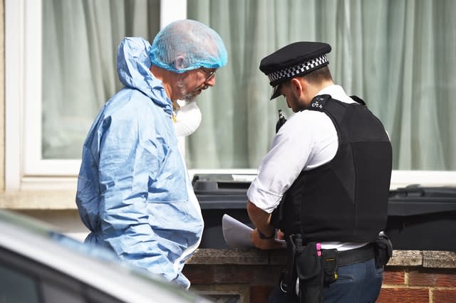 A forensic officer speaks with a police officer at the scene in Raymead Avenue, Thornton Heath, Croydon 
