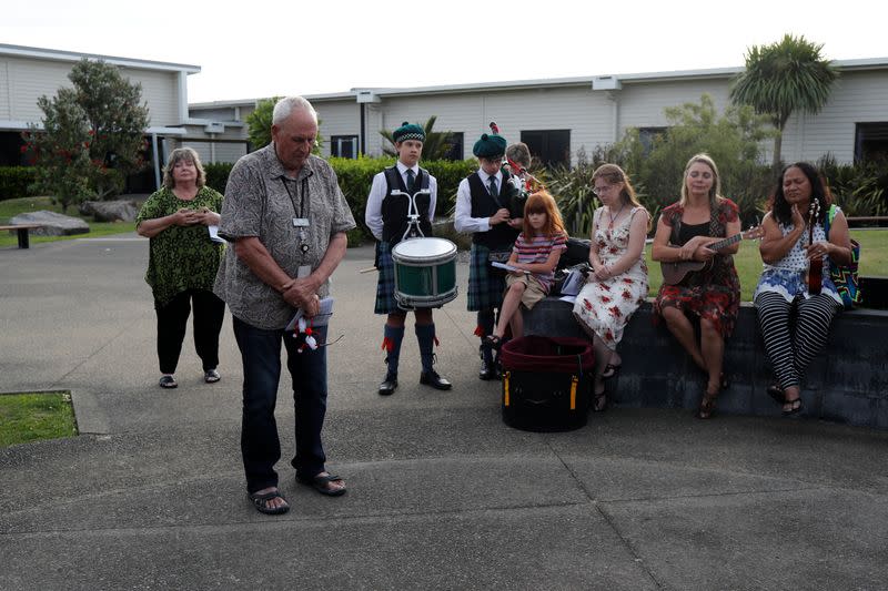 People observe a minute of silence as the pay their respects to the victims of the White Island volcano eruption, at the hospital in Whakatane