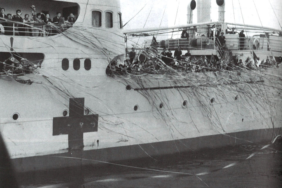 In this reproduction of the undated photo, ethnic Korean residents of Japan and their family members wave from a ship at a port in Niigata leaving for North Korea under a resettlement program that promised them a "Paradise on Earth," a place where they could live happily without being discriminated against as ethnic Koreans. (Harunori Kojima via AP)