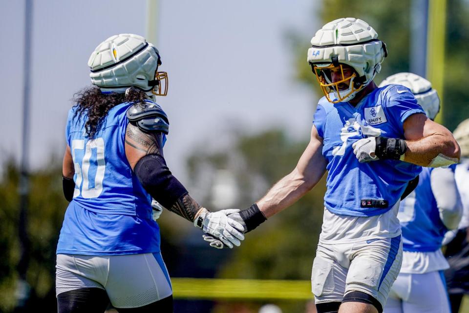 Chargers linebacker Joey Bosa (97) congratulates defensive tackle David Moa (50) during a joint practice with the Saints.