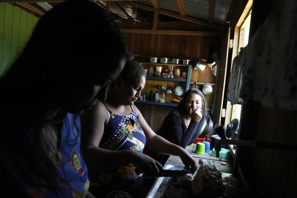 A family prepares food at a home in Lago Serrado community, near Carauari, Brazil, Thursday, Sept. 1, 2022. A Brazilian non-profit has created a new model for land ownership that welcomes both local people and scientists to collaborate in preserving the Amazon. (AP Photo/Jorge Saenz)