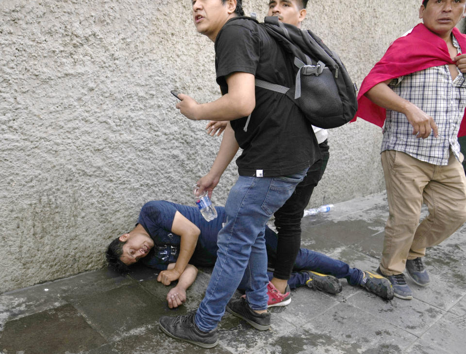 An injured demonstrator, part of the anti-government protesters who traveled to the capital from across the country to march against Peruvian President Dina Boluarte, lies injured on the ground during clashes with the police in Lima, Peru, Thursday, Jan. 19, 2023. Protesters are seeking immediate elections, Boluarte's resignation, the release of ousted President Pedro Castillo and justice for the dozens of protesters killed in clashes with police. (AP Photo/Martin Mejia)