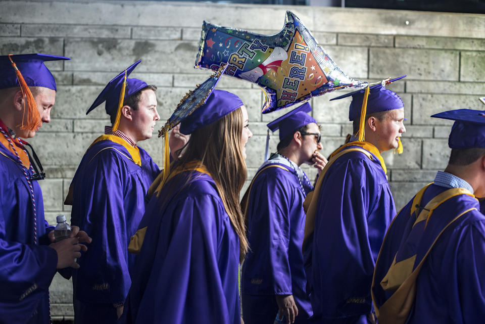 File - Graduates walk onto the field at Bridgeforth Stadium for the James Madison University commencement in Harrisonburg, Va., on May 5, 2017. With the help of a nonprofit that focuses on civic education, the presidents of a wide-ranging group of 13 universities have decided to elevate free speech on their campuses this academic year. (Stephen Swofford/Daily News-Record Via AP, File)