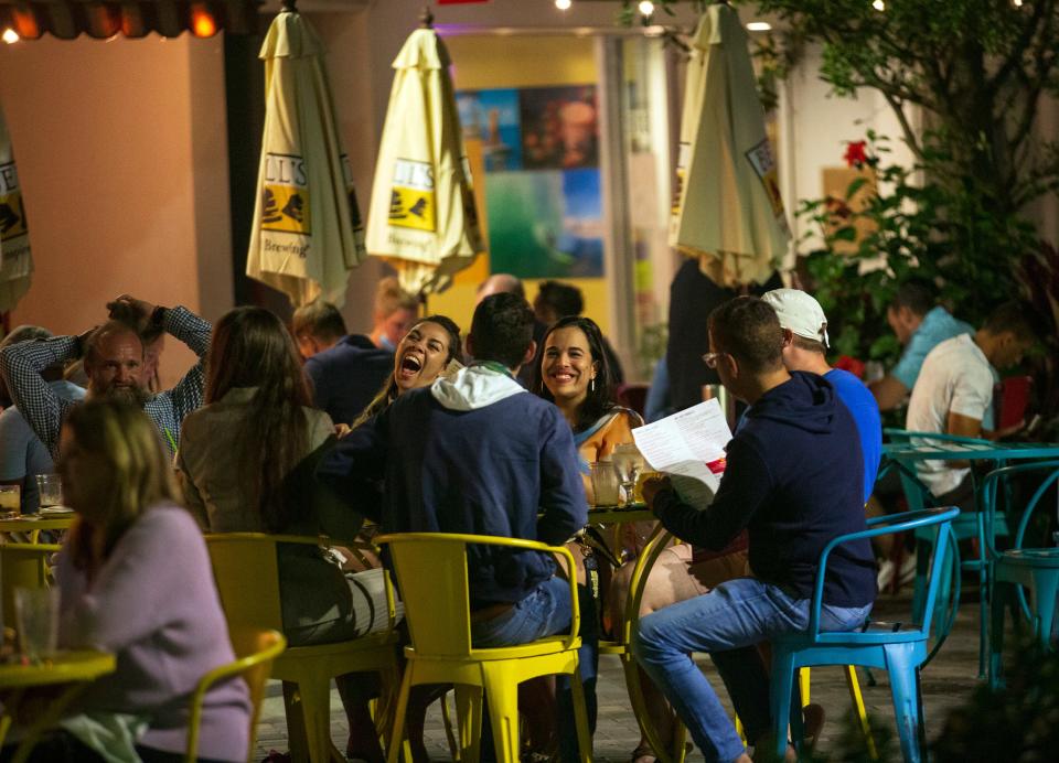 People dine at tables set up in the street on the 500 block of Clematis Street in downtown West Palm Beach.