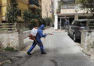 A municipal worker wearing protective gear sprays disinfectant to help prevent the spread of the coronavirus, on a street in Beirut, Lebanon, Tuesday, March 31, 2020. (AP Photo/Hussein Malla)
