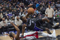 Sacramento Kings guard De'Aaron Fox (5) tumbles over Houston Rockets guard Eric Gordon during the second half of an NBA basketball game in Sacramento, Calif., Friday, Jan. 14, 2022. The Kings won 126-114. (AP Photo/Randall Benton)