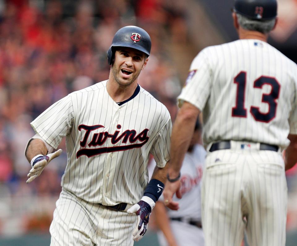 Minnesota Twins' Joe Mauer celebrates his home run with Twins' third base coach Gene Glynn against the Detroit Tigers in the first inning during a baseball game Saturday, Aug. 18, 2018, in Minneapolis. (AP Photo/Andy Clayton-King)