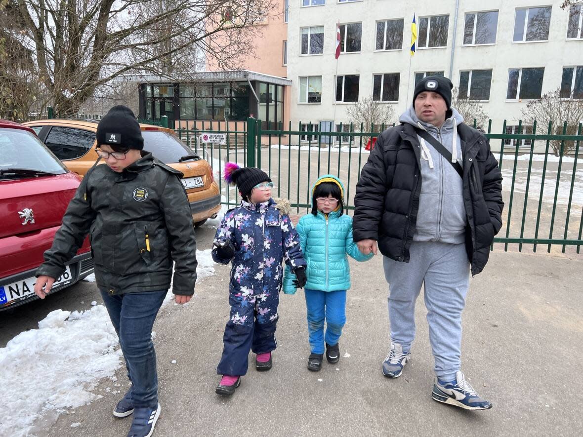 Evgeny Mezhevoy, far right, was reunited with his three children - from left, Matvey, 13; Sviatoslava, 9; and Alexandra, 7 - after a two-month separation. The family is originally from outside Mariupol, Ukraine, but the kids ended up at a camp in Moscow. (Corinne Seminoff/CBC - image credit)