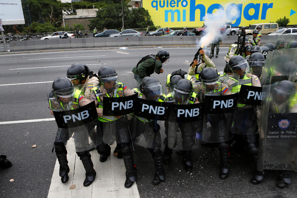 <p>A riot policeman shoots tear gas during a clash with opposition supporters at a rally to demand a referendum to remove President Nicolas Maduro in Caracas, June 7, 2016. (Reuters/Ivan Alvarado) </p>