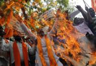 Supporters of Rashtrawadi Shiv Sena, a Hindu hardline group, shout slogans as they burn an effigy depicting Jammu and Kashmir chief minister Omar Abdullah during a protest against Thursday's militant attack in Jammu, in New Delhi September 27, 2013. Militants dressed in Indian army uniforms attacked Indian police and soldiers near the border with Pakistan on Thursday, killing nine people and triggering calls for talks between the prime ministers of the rival nations to be called off. The placards read: "Immediately dismiss government of Jammu and Kashmir" and "Declare Pakistan a terrorist state". (REUTERS/Adnan Abidi)