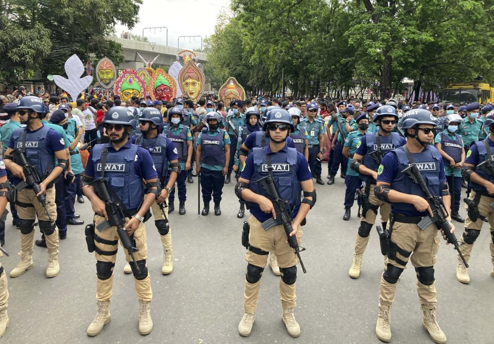 Security officers guard a procession being taken out to mark the Bengali New Year in Dhaka, Bangladesh, Wednesday, April 14, 2022. After a two-year break, thousands of people in Bangladesh and Nepal on Thursday celebrated their respective new years with colorful processions and musical soirees as the coronavirus pandemic eased and life swung back to normal. (AP Photo/Al Emrun Garjon)