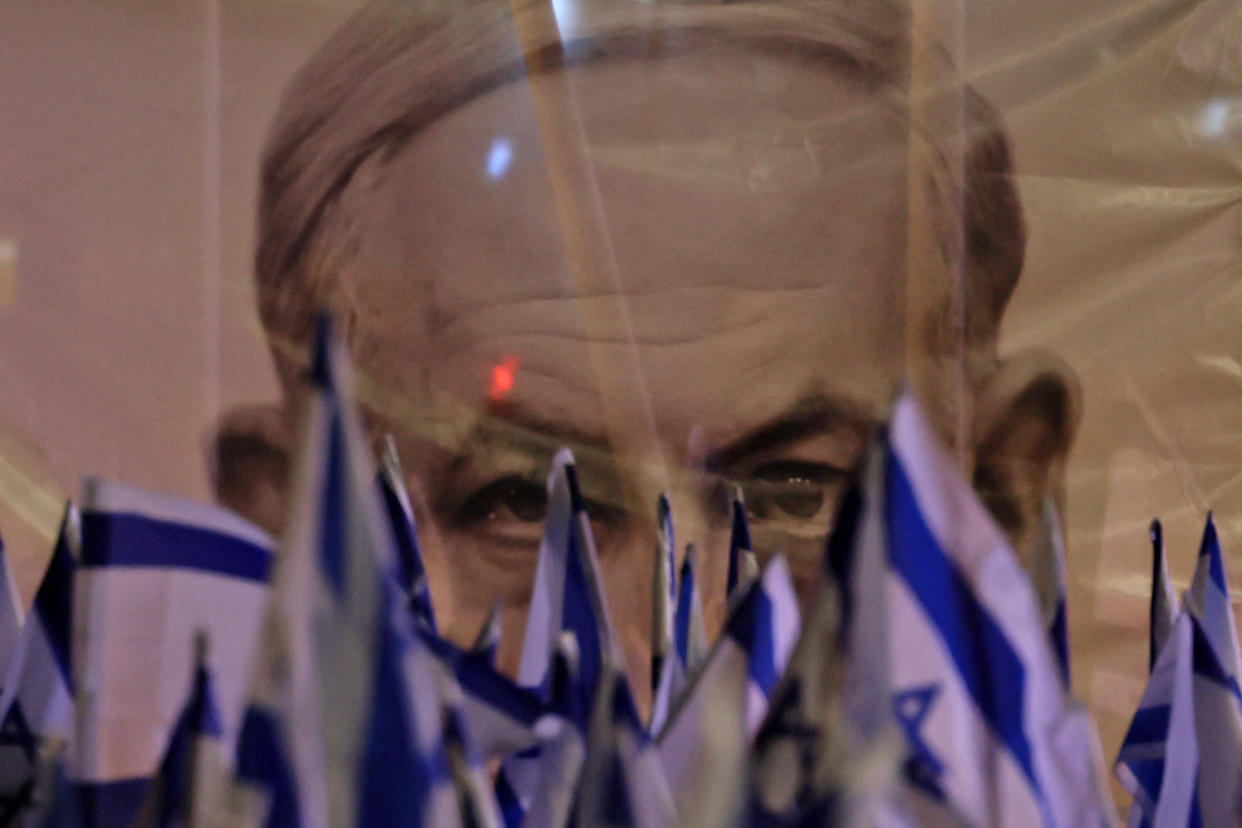 An image of Prime Minister Benjamin Netanyahu looms over a protest in Tel Aviv