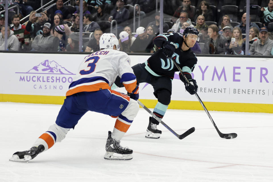 Seattle Kraken center Jaden Schwartz (17) shoots as New York Islanders defenseman Adam Pelech (3) defends during the second period of an NHL hockey game Thursday, Nov. 16, 2023, in Seattle. (AP Photo/John Froschauer)