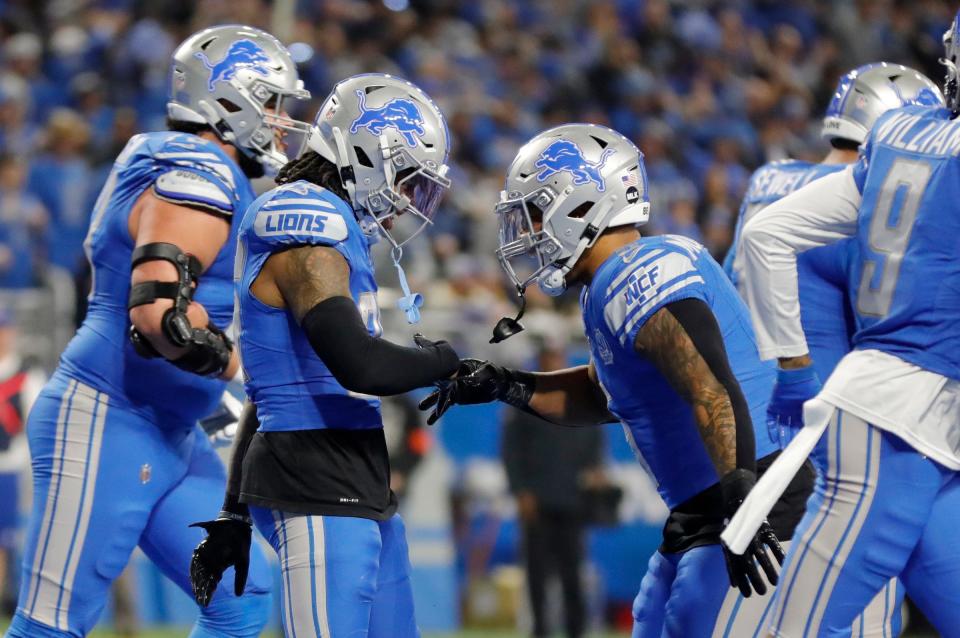 Detroit Lions running backs Jahmyr Gibbs and David Montgomery celebrate after Gibbs scored a touchdown in the first half against the L.A. Rams at Ford Field in Detroit on Sunday, Jan. 14, 2024.
