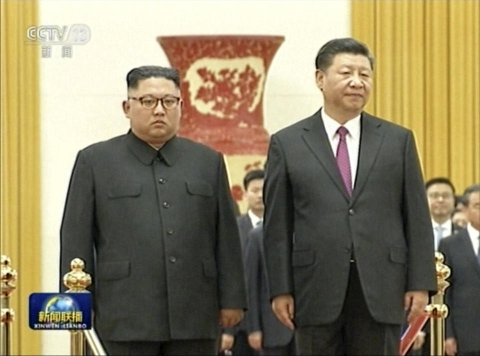 <em>Chinese President Xi Jinping, right, stands next to Kim Jong-un during a welcome ceremony at the Great Hall of the People in Beijing (AP)</em>