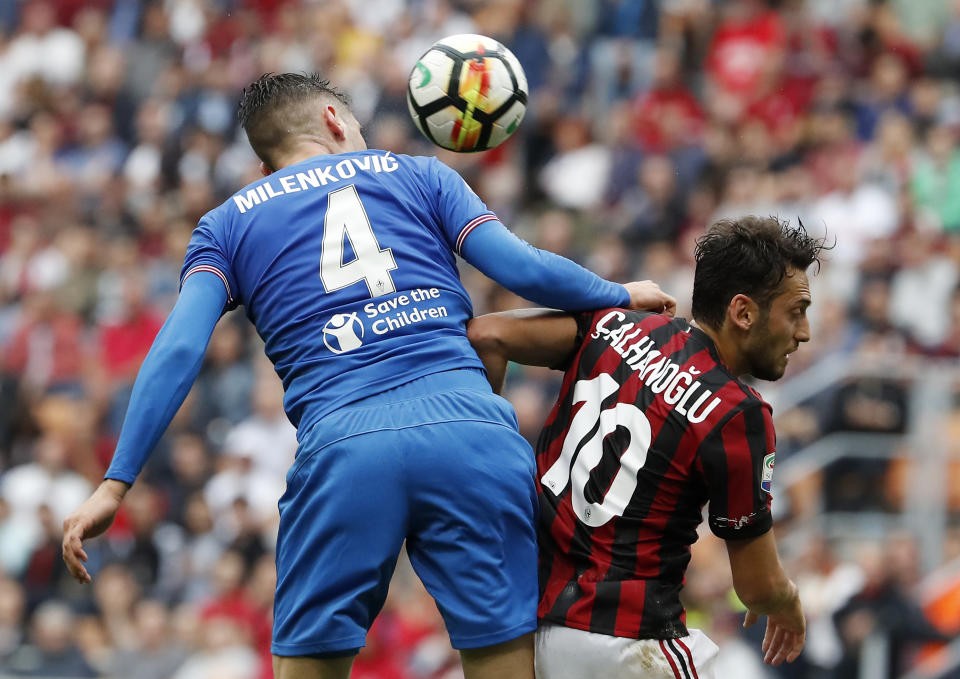 Fiorentina's Nikola Milenkovic, left, jumps for the ball with AC Milan's Hakan Calhanoglu during the Serie A soccer match between AC Milan and Fiorentina at the San Siro stadium in Milan, Italy, Sunday, May 20, 2018. (AP Photo/Antonio Calanni)