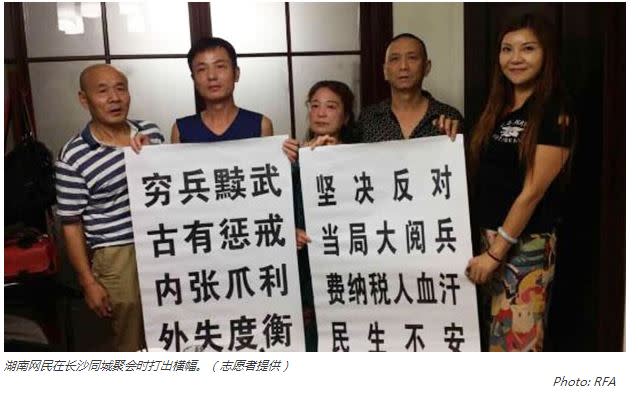 中國湖南民眾聚餐拍照時手拿反閱兵標語，圖片截自《自由亞洲電台》