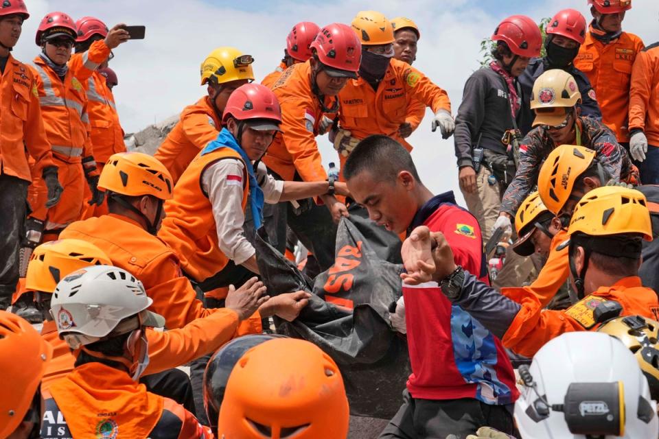 Rescuers recover the body of a victim of the earthquake in Indonesia.  (AP)