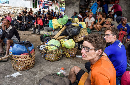 Indonesian and foreign climbers are seen after walking down from Rinjani Mountain at Sembalun village in Lombok Timur, Indonesia, July 29, 2018. Picture taken July 29, 2018. Antara Foto/Ahmad Subaidi/via REUTERS