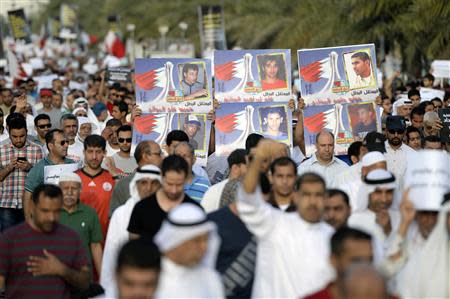 Protesters hold banners as they shout anti-government slogans during a protest in Budaiya west of Manama, April 4, 2014. REUTERS/Stringer