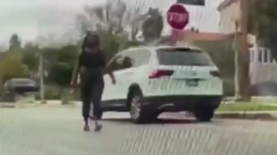 A woman exiting her Volkswagen Tiguan SUV to throw large bricks at car windshields in Los Angeles. (Citizen)