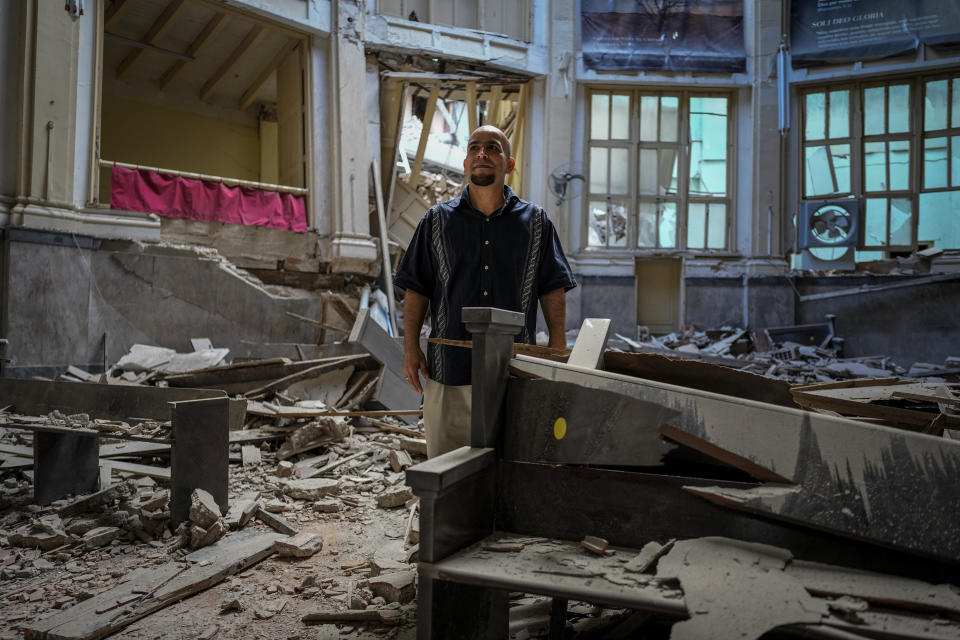 Rev. Barbaro Abel Marrero Castellanos, president of the Baptist Convention of Western Cuba, poses for a photo inside the Calvary Baptist Church damaged by an explosion that devastated the Hotel Saratoga which is located next door, in Old Havana, Cuba, Wednesday, May 11, 2022. “We still don't know exactly the magnitude of the damage," said Marrero Castellanos, adding that some specialists have said they might have to evaluate possibly demolishing parts of the structure. (AP Photo/Ramon Espinosa)