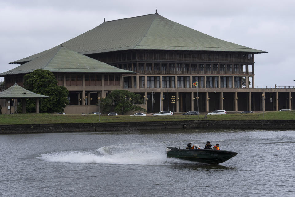 Army soldiers patrol outside the Parliament building in Colombo, Sri Lanka, Wednesday, July 20, 2022. Sri Lanka's Parliament is voting by secret ballot Wednesday for a new president to lead the country out of a deep political, economic and humanitarian crisis. (AP Photo/Rafiq Maqbool)