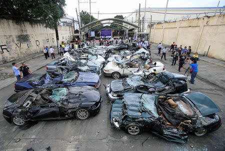 A bulldozer destroys condemned smuggled luxury cars worth 61,626,000.00 pesos (approximately US$1.2 million), which include used Lexus, BMW, Mercedes-Benz, Audi, Jaguar and Corvette Stingray, during the 116th Bureau of Customs founding anniversary in Metro Manila, Philippines February 6, 2018. REUTERS/Romeo Ranoco