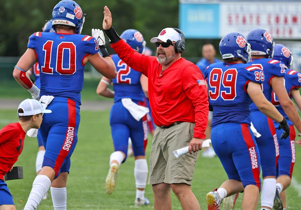 Lenawee Christian head coach Bill Wilharms greets his team as they come off the field during last week's game against Britton Deerfield.