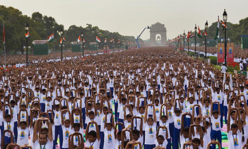 Indians perform yoga on Rajpath, in New Delhi, India, Sunday, June 21, 2015. Millions of yoga enthusiasts are bending their bodies in complex postures across India as they take part in a mass yoga program to mark the first International Yoga Day. (AP Photo/ Manish Swarup)