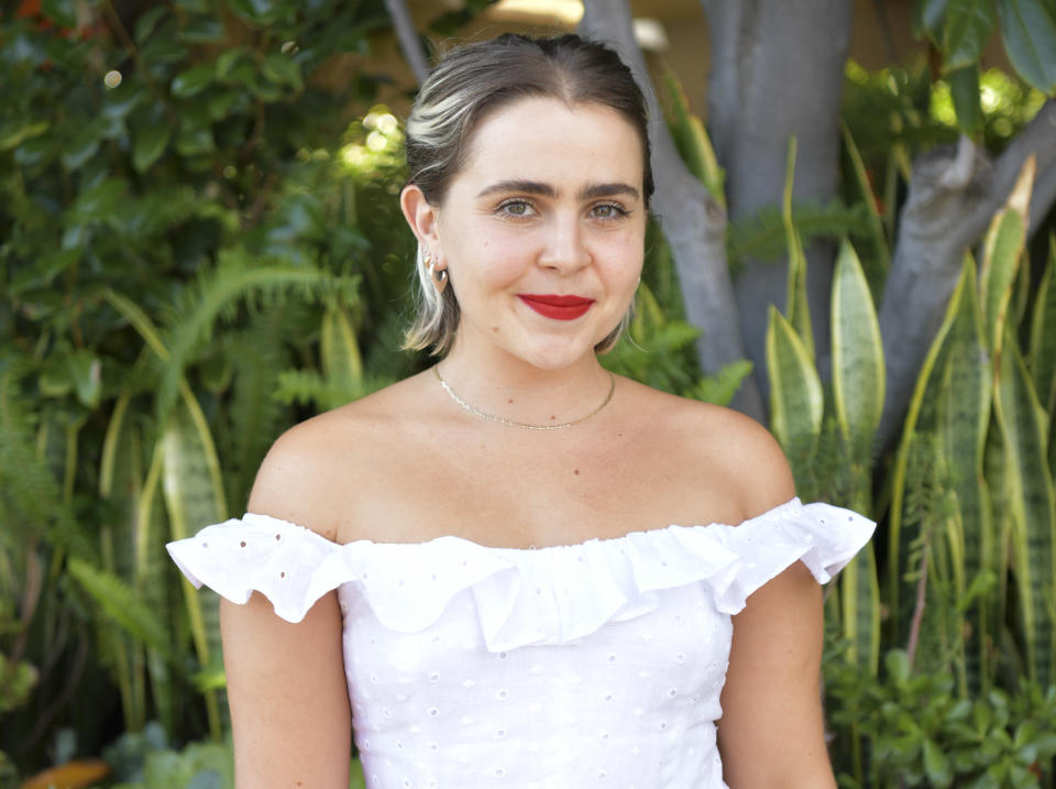 Mae wears a white off the shoulder eyelet top