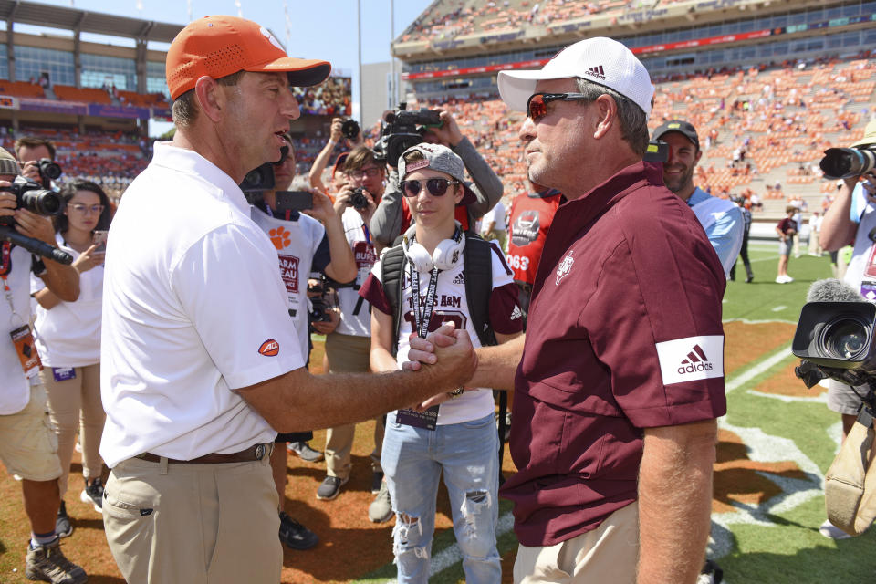 Clemson head coach Dabo Swinney, left, greets Texas A&M head coach Jimbo Fisher, while Jimbo's son Ethan, center, watches before the start of an NCAA college football game against Texas A&M Saturday, Sept. 7, 2019, in Clemson, S.C. (AP Photo/Richard Shiro)