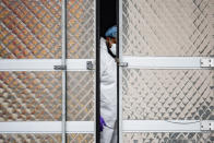 A medical worker wearing personal protective equipment due to COVID-19 concerns works inside a refrigerated container truck functioning as a makeshift morgue, Tuesday, March 31, 2020, at Brooklyn Hospital Center in the Brooklyn borough of New York. The new coronavirus causes mild or moderate symptoms for most people, but for some, especially older adults and people with existing health problems, it can cause more severe illness or death. (AP Photo/John Minchillo)