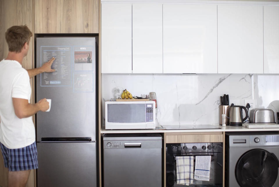 A man using a touchscreen fridge