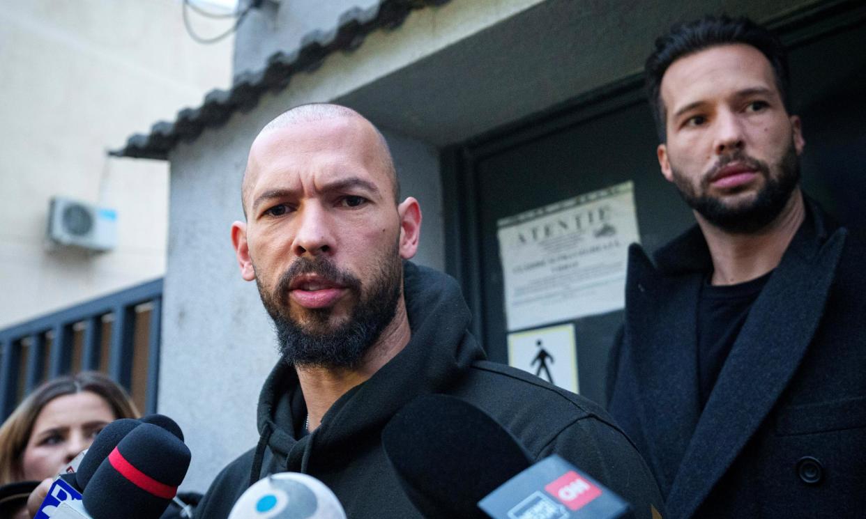 <span>Andrew Tate, left, and his brother Tristan Tate talk to reporters after leaving a police detention facility in Bucharest, Romania, in March 2024.</span><span>Photograph: Andreea Alexandru/AP</span>