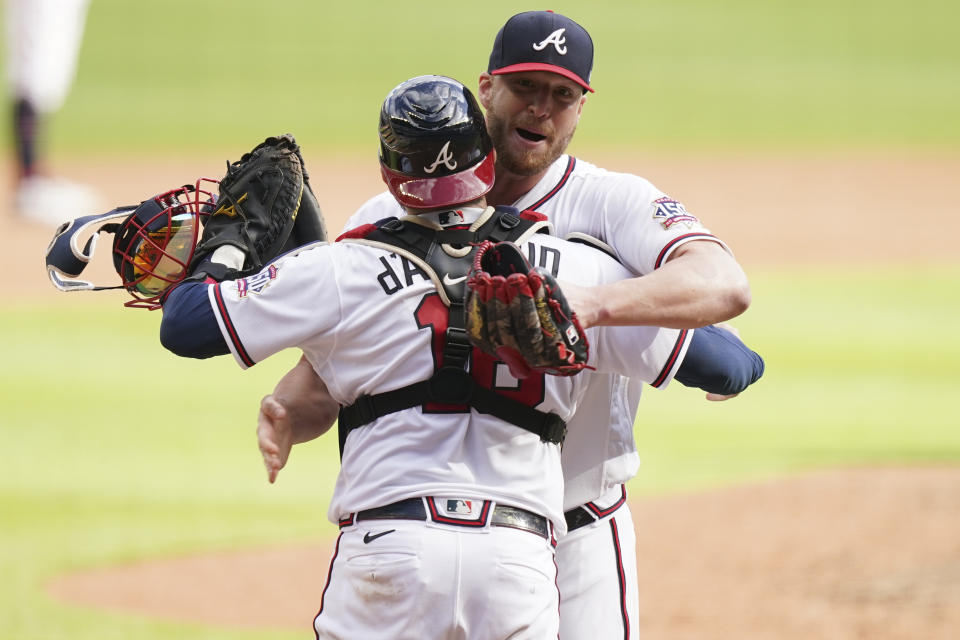 Atlanta Braves closer Will Smith (51) celebrates with Atlanta Braves catcher Travis d'Arnaud (16) embrace after the ninth inning of Game 3 of a baseball National League Division Series against the Milwaukee Brewers, Monday, Oct. 11, 2021, in Atlanta. The Atlanta Braves won 3-0. (AP Photo/Brynn Anderson)