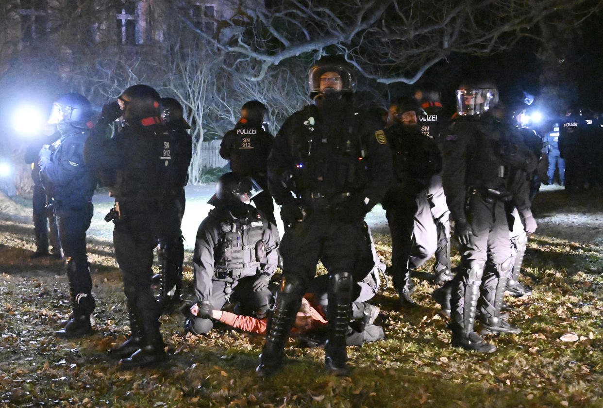 Police officers arrest a demonstrator in the city centreof Bautzen, Germany, during protests against Corona measures and a possible compulsory vaccination in Germany, Monday evening, Jan. 3, 2022. Tens of thousands of people took to the streets in scores of German towns and cities for weekly marches that have organizers have labeled ‘strolls’ in an attempt to bypass restrictions on public gatherings. Most of the rallies passed peacefully, though many broke rules on social distancing, prompting officers to intervene. (Robert Michael/dpa via AP)