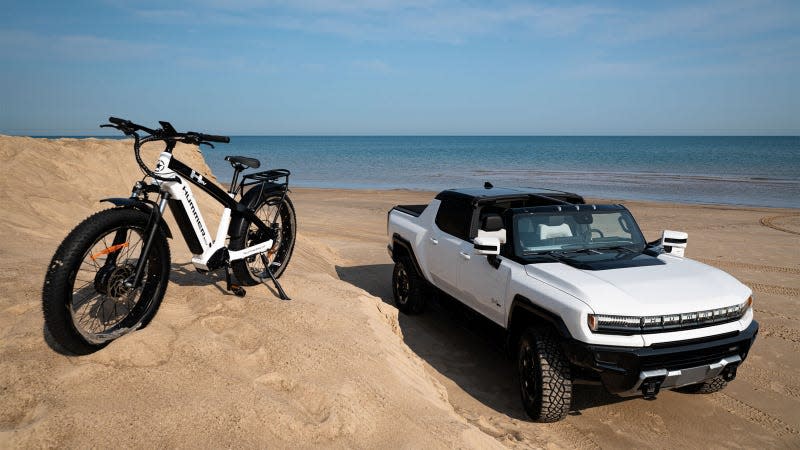 A photo of a Hummer electric bike next to an EV pickup truck. 