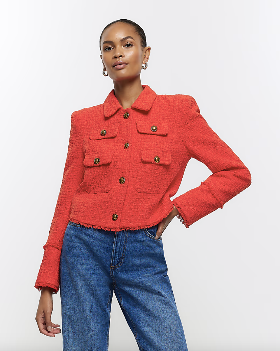 model wearing blue jeans and red tweed buttoned jacket, Red Boucle Trophy Blazer (Photo via River Island)