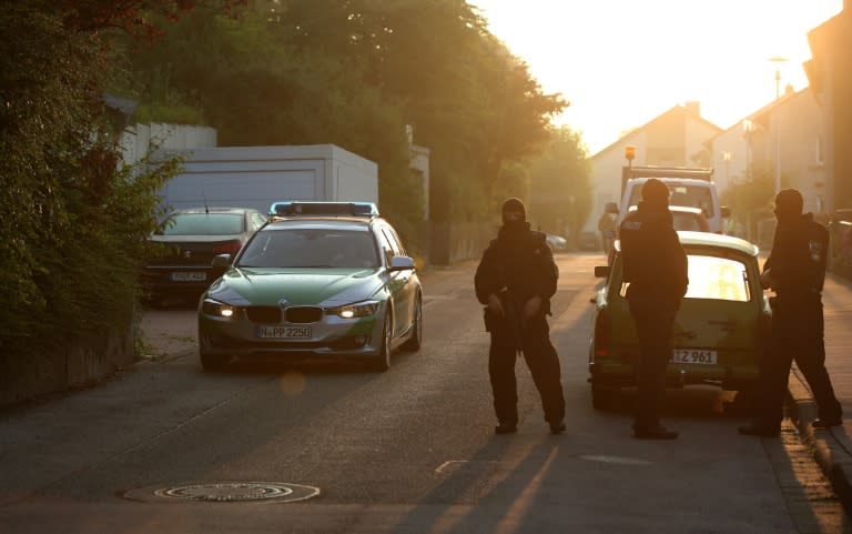 Police stand guard outside the home of a Syrian migrant in Ansbach on 25 June, 2016