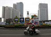 A police officer rides his motorcycle past a countdown clock for the 18th Asian Games in Jakarta, Indonesia March 8, 2018. REUTERS/Willy Kurniawan