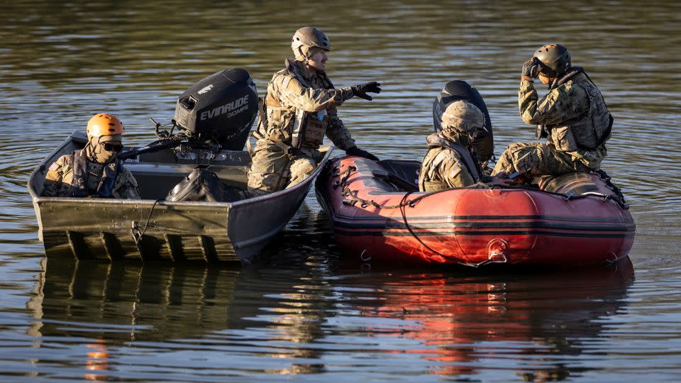National Guard soldiers stop Tuesday to talk while patrolling the Rio Grande at the US-Mexico border in Eagle Pass, Texas. - John Moore/Getty Images