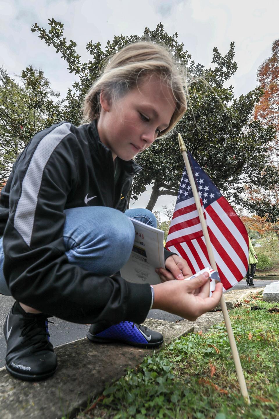 Lola Thompson, 11, leaves an "I Voted Today" wristband at the grave of Mary Parker Verhoeff at Cave Hill Cemetery.  The stop was part of the tour of area suffragists on election day.  The tour was put on by the League of Women Voters Louisville, Frazier History Museum, Friends of Eastern Cemetery and Cave Hill Cemetery.November 5, 2019