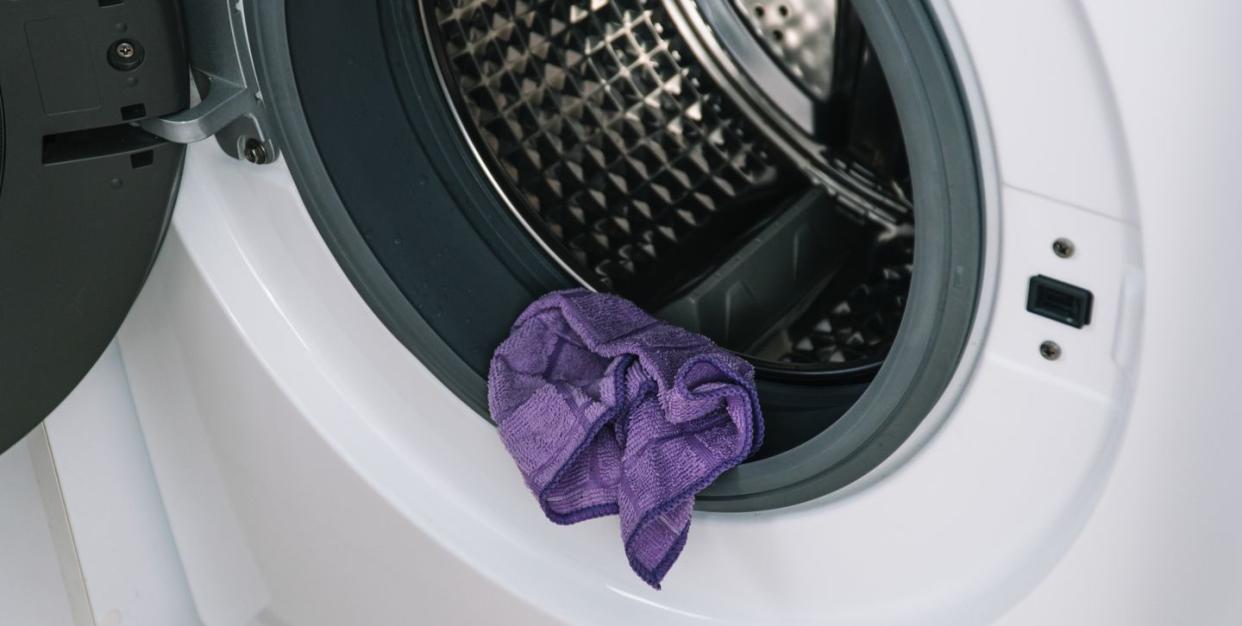 purple rag resting on edge of washing machine