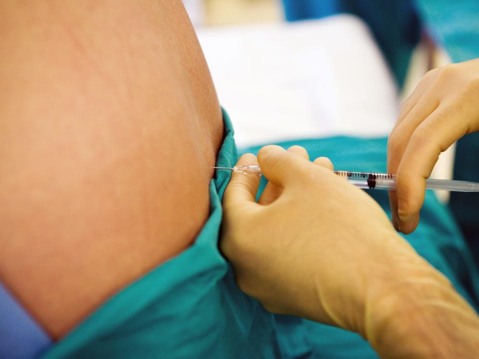 A patient is injected with a solution into their spine