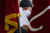 A man examines his ballot during the State Duma, the Lower House of the Russian Parliament and local parliaments elections at a polling station in St. Petersburg, Russia, Saturday, Sept. 18, 2021. Sunday will be the last of three days voting for a new parliament, but there seems to be no expectation that United Russia, the party devoted to President Vladimir Putin, will lose its dominance in the State Duma. (AP Photo/Dmitri Lovetsky)