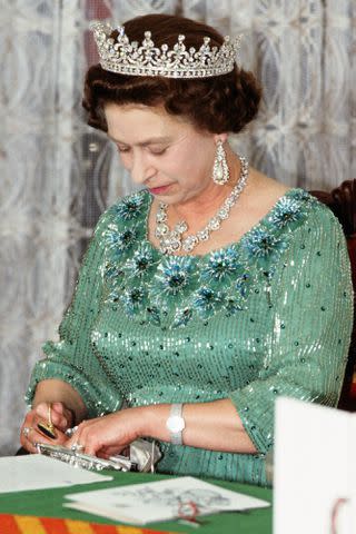<p>Tim Graham Photo Library via Getty</p> Queen Elizabeth at a state banquet in Kenya in 1983.