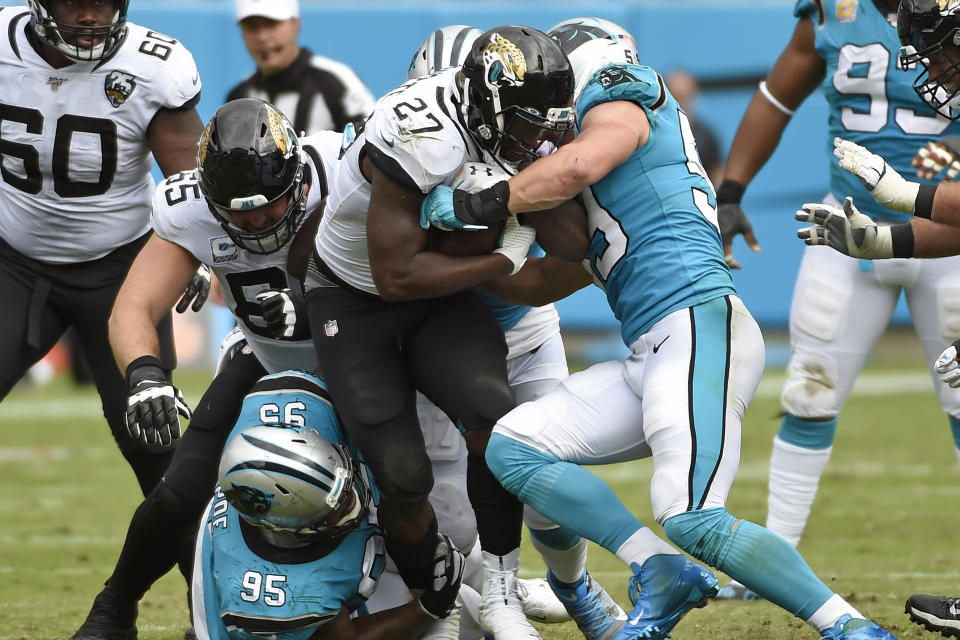 Carolina Panthers defensive tackle Dontari Poe (95) and middle linebacker Luke Kuechly (59) tackle Jacksonville Jaguars running back Leonard Fournette (27) during the second half of an NFL football game in Charlotte, N.C., Sunday, Oct. 6, 2019. (AP Photo/Mike McCarn)