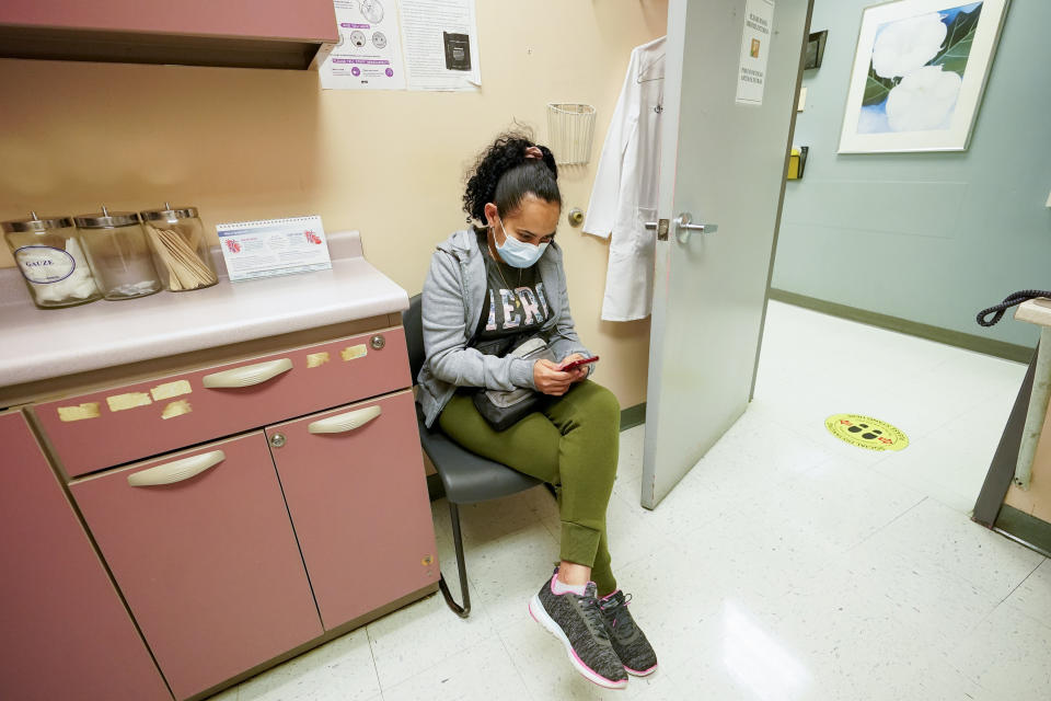 Geidy Chirinos sits in an observation area after being inoculated with the second dose of the Moderna COVID-19 vaccine, Wednesday, May 12, 2021, at the Joseph P. Addabbo Family Health Center in the Far Rockaway neighborhood of the Queens borough of New York. (AP Photo/Mary Altaffer)